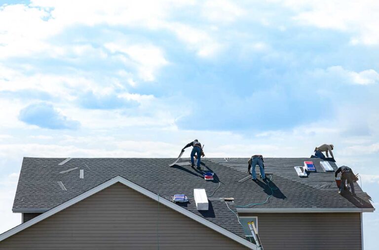 A homeowner examines a weathered roof with missing shingles and visible wear after a recent storm.